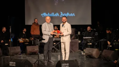 Sanat Merkezinde gerçekleştirilen ilahi dinletisi sonrasında Beyhan’a kayısı takdim eden